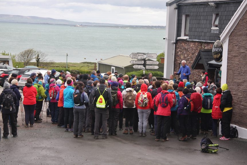 Photograph of walkers at the start of a day of hiking with the sea in the backgrouind
